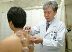 한상원 대구한의대부속 대구한방병원 교수가 어깨결림증 환자에게 부항치료를 하고 있다.