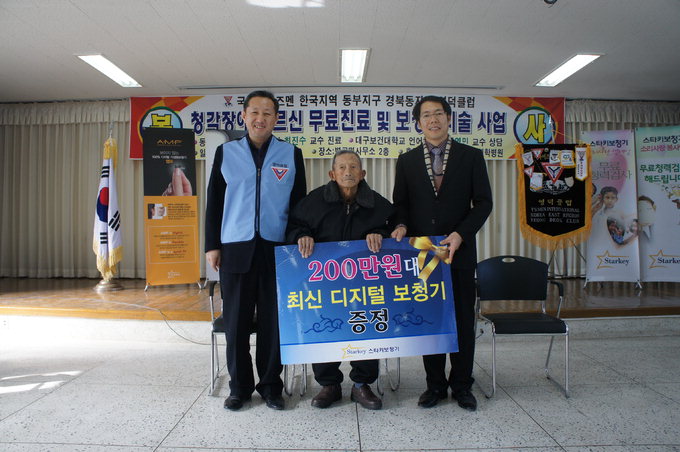 박진현 국제와이즈멘 영덕클럽 회장(왼쪽)과 김영민 스타키보청기 대표가 올해 104세인 장경선 어르신께 보청기를 전한 뒤 기념사진을 찍고 있다.