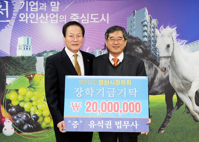 유석권 법무사(오른쪽)가 27일 영천시장학회 이사장인 김영석 시장에게 2천만원의 장학기금을 전한 후 기념촬영을 하고 있다.