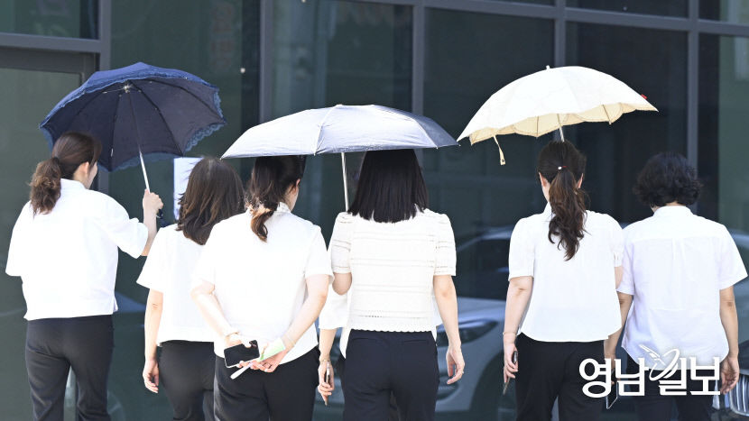 [포토뉴스] 폭염 속 양산 나눠쓰는 시민들