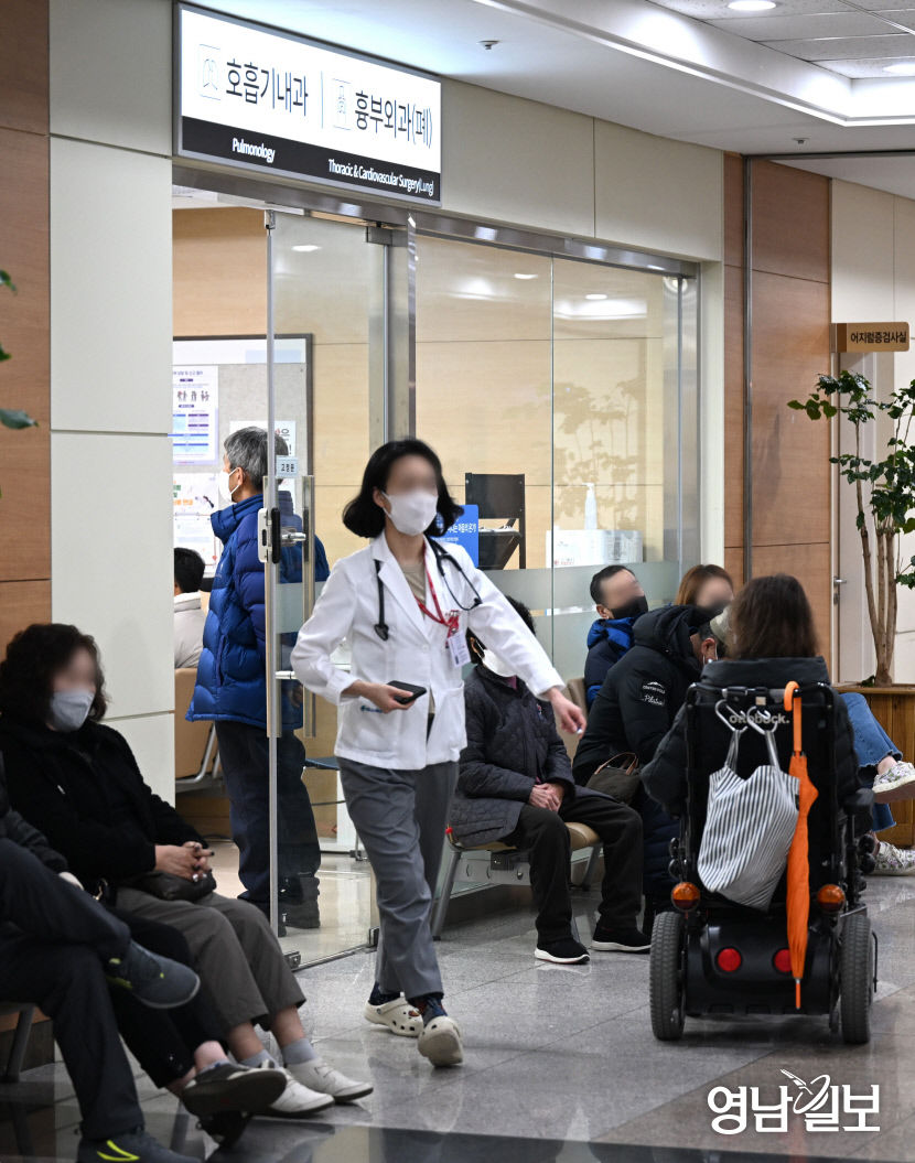 [포토뉴스] 전공의 사직서 제출 사흘째…진료 대기하는 시민들 옆 지나는 의료진