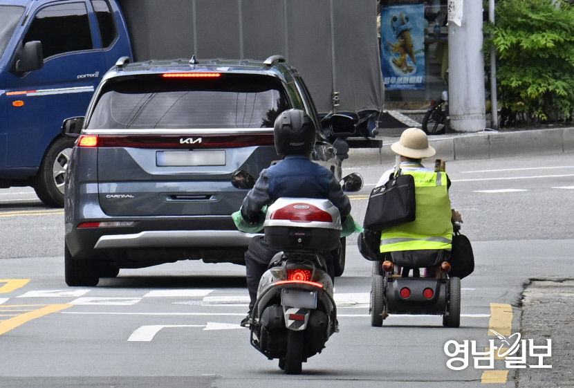 [포토뉴스]전동 휠체어 타고 아찔한 차도 주행