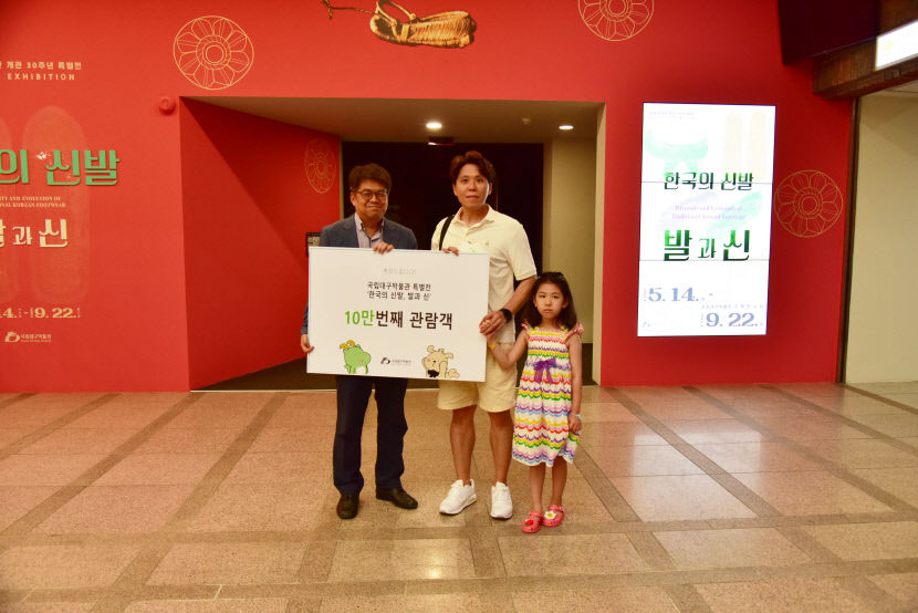 국립대구박물관 특별전 '한국의 신발, 발과 신' 10만번째 관람객인 정현철씨(가운데)가 김규동 국립대구박물관장(왼쪽)과 기념촬영을 하고 있다.<국립대구박물관 제공>
