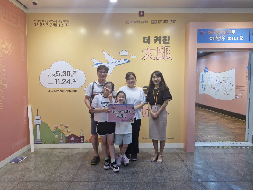 대구근대역사관 특별기획전 '더 커진 大邱, 군위를 품은 대구'의 1만 번째 관림객으로 입장한 오병규씨 가족이 기념촬영을 하고 있다.<대구문화예술진흥원 제공>