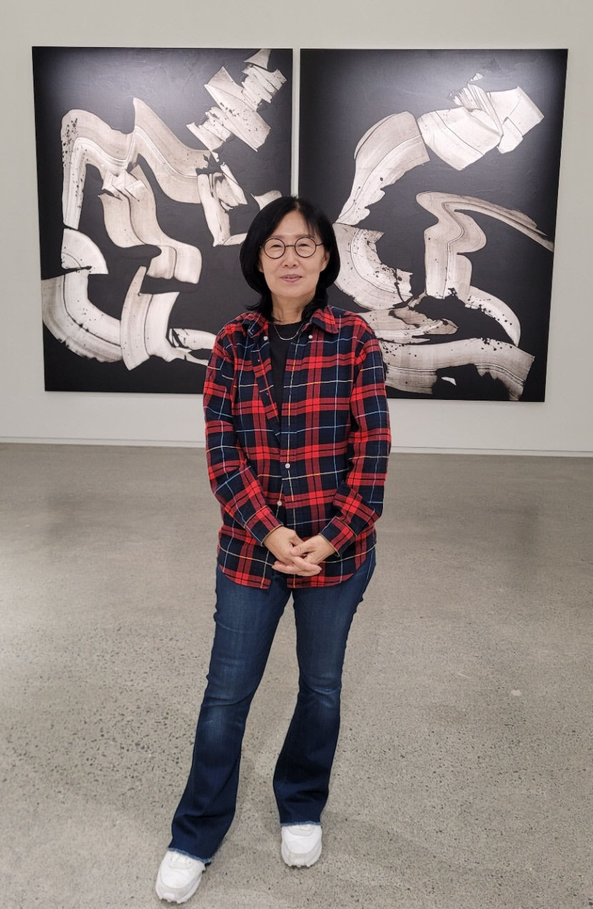 유주희 작가가 자신의 작품 앞에서 포즈를 취하고 있다