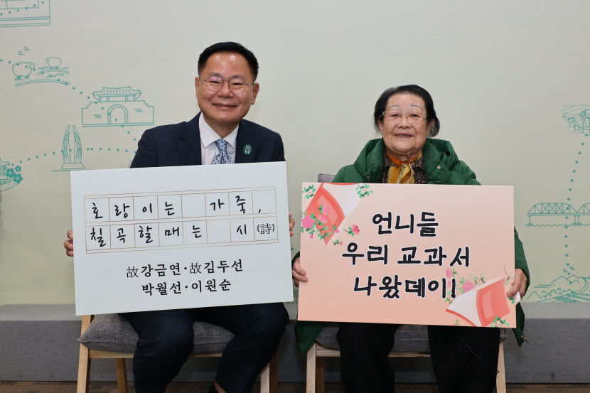 천재교과서에 자신의 시가 실린 이원순 할머니가 김재욱 칠곡군수와 교과서 수록을 기념하는 푯말을 들고 기념촬영을 하고 있다. <칠곡군 제공>