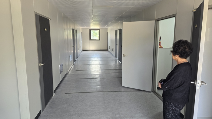 황말숙 할머니가 텅빈 임시주택 복도를 바라보고 있다.