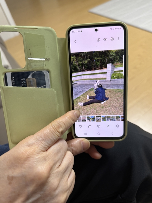 지난 26일 만난 송인숙 상인동 가스 폭발 참사 희생자 유족회장이 자신의 핸드폰을 통해 유족들이 참사 희생자 위령탑을 청소하는 사진을 보여주고 있다.