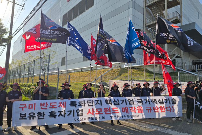 SK실트론 노동조합원들이 회사 매각 규탄 현수막을 들고 집회를 하고 있다. <박용기 기자>
