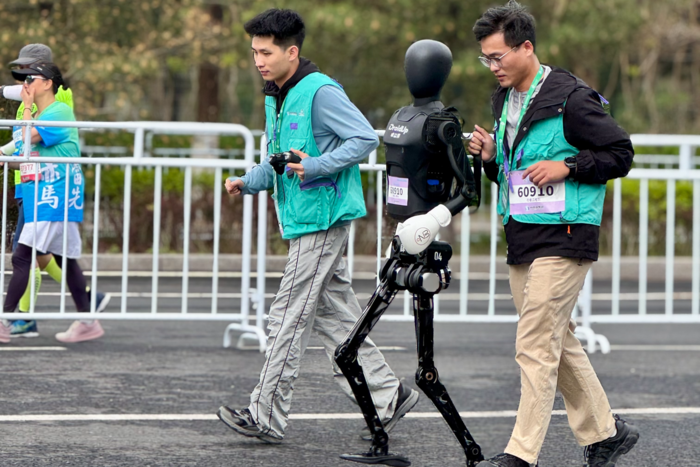 19일 중국 베이징에서 열린 휴머노이드 로봇 하프 마라톤에서 드로이드업이 제작한 X02가 사람과 함께 달리고 있다. <박영민기자>