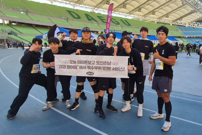 13일 제18회 영남일보 국제 하프마라톤대회에 참가한 고깃집 겹겹 범어점 직원들이 오늘 마라톤 보고 오신 손님께 특수부위 1인분 서비스라는 문구가 적힌 플래카드를 들고 인증샷을 찍고 있다. <조윤화기자>