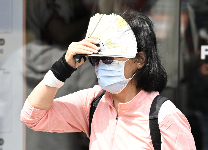 대구지역 낮 최고기온 29℃를 기록한 지난달 18일 오후 대구 중구 동성로를 찾은 한 시민이 부채로 햇빛을 가리며 이동하고 있다. 대구 기상청 관계자는