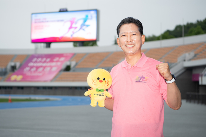 김장호 아시아육상경기선수권대회 조직위원회 공동위원장(구미시장)이 주경기장인 구미스타디움에서 마스코트 인형 '러닝토미'를 들고 환하게 웃고 있다.<구미시 제공>