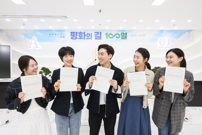 신천지예수교회 성도들이 인 맞음 확인 시험지를 들고 밝게 웃고 있다. <신천지 대구교회 제공>