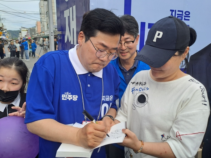 박찬대 더불어민주당 상임총괄선거대책위원장이 상주시 풍물시장을 찾아 이재명 더불어민주당 후보에 대한 지지를 호소하고 한 시민에게 사인을 해주고 있다. 강남진기자