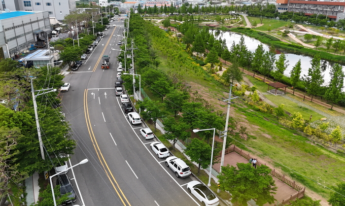 대구 달성군이 성서5차 산업단지 내 4차로 이상 도로 2.3km 구간에 조성한 노상주차장. 총 238면이 신규 확보되면서 단지 내 주차난 해소에 기여할 것으로 기대된다. 오른쪽은 세천늪테마정원 일대.<달성군 제공>