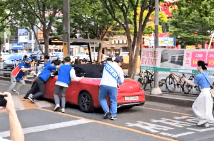 26일 오후 대구 수성구 더불어민주당 이재명 후보의 한 유세 현장에서 차량이 경적을 울리며 유세를 방해하던 차량이 선거운동원들이 제지하자, 선거운동원들을 차로 밀고 나가고 있다. <독자 제공>