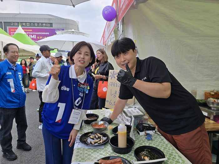 조국혁신당 박은정 국회의원이 2025 구미아시아육상경기선수권대회가 열리는 구미시민운동장 아래 아시안푸드페스타 행사장에서 한 상인과 사진을 찍고 있다.<박용기 기자>