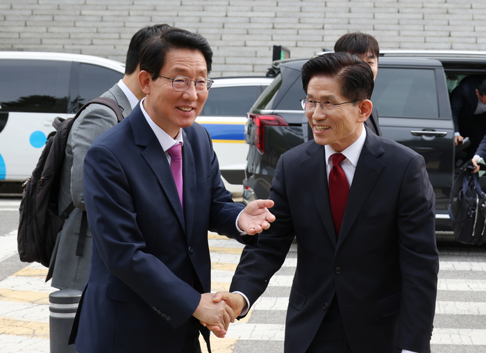 국민의힘 김문수 대선 후보(오른쪽)가 8일 무소속 한덕수 대선 후보와의 단일화 관련 회동을 하기 위해 서울 여의도 국회에 도착해 국민의힘 김상훈 정책위원장과 악수하고 있다. 연합뉴스