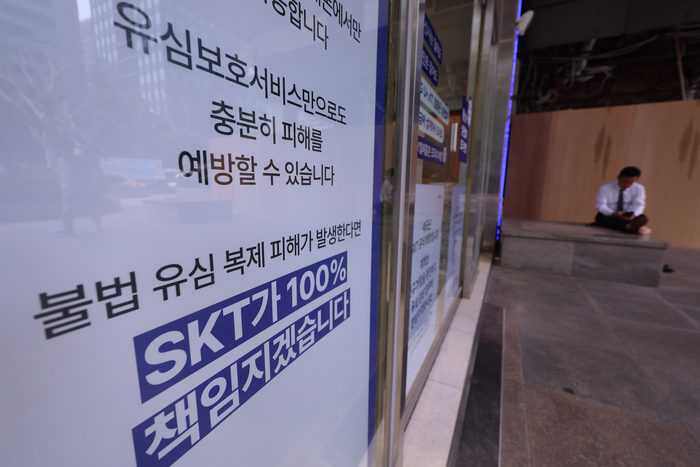 유심정보 유출 사태를 수습 중인 SK텔레콤이 도서 벽지에 거주하는 고객을 직접 찾아가 유심을 교체하거나 재설정해주는 서비스를 내주부터 시작할 전망이다. 사진은 14일 서울 시내 한 SKT 매장에 붙은 유심정보 유출 사태 관련 안내문. <연합뉴스>