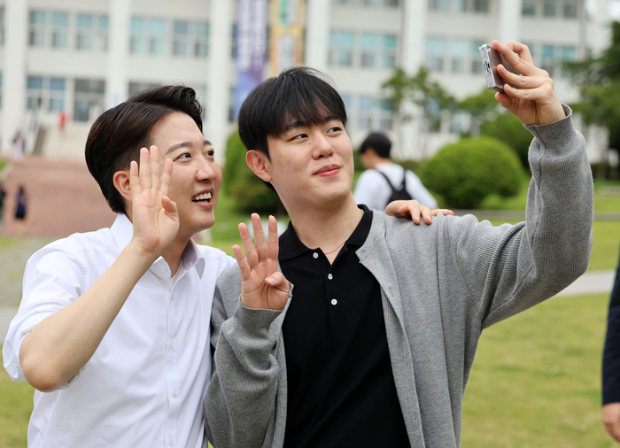 개혁신당 이준석 대선 후보가 20일 광주 북구 전남대학교 학생회관 앞에서 한 학생과 사진을 찍고 있다. 연합뉴스