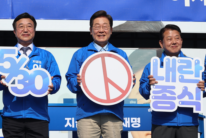 더불어어민주당 이재명 대선 후보가 26일 경기 남양주시 평내호평역 광장에서 열린 유세에서 사전투표를 독려하는 패널을 들어 보이고 있다. 연합뉴스