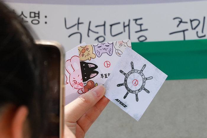 21대 대통령 선거 사전투표 둘째날인 30일 서울 관악구 낙성대동주민센터에 마련된 낙성대동사전투표소에서 투표를 마친 유권자들이 투표 인증 용지를 촬영하고 있다. 연합뉴스