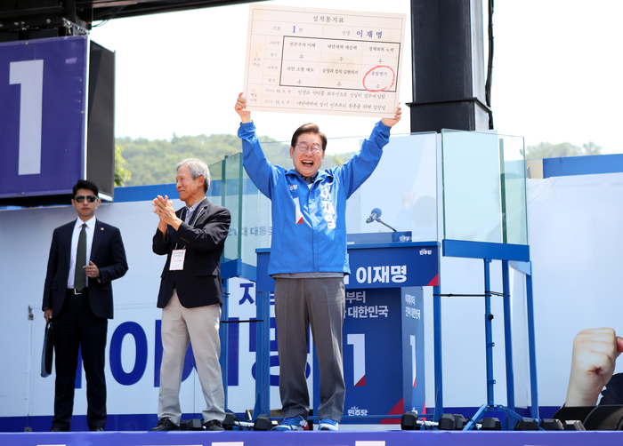 이재명 후보가 1일 안동 유세 현장에서 초등학교 은사인 박병기 선생이 준 '성적표'를 높이 들고 지지를 호소하고 있다.<피재윤 기자>