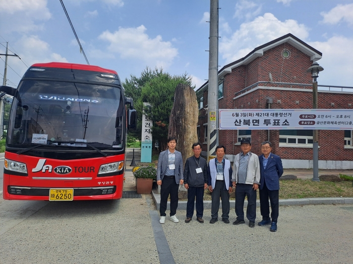 문경시 직원과 주민들이 문경 산북면 투표소 앞에서 기념 촬영을 하고 있다. 강남진 기자
