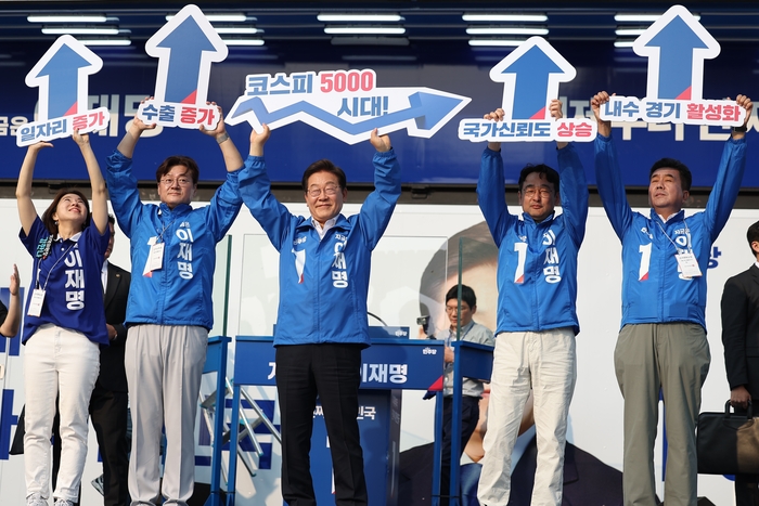 이재명 대통령이 대선 기간이던 지난달 29일 서울 서초구 고속버스터미널 앞에서 열린 유세에서 '코스피 5000 시대' 피켓을 들어보이며 경제회복 퍼포먼스를 하고 있다. 연합뉴스