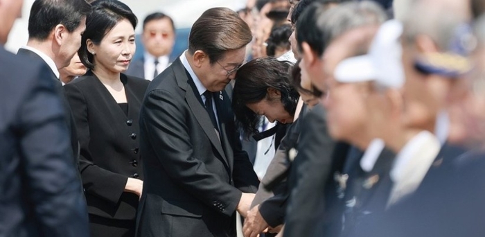 이재명 대통령이 6일 서울 동작구 국립서울현충원에서 열린 70회 현충일 추념식에 입장하며 한 유족을 위로하고 있다. 연합뉴스.