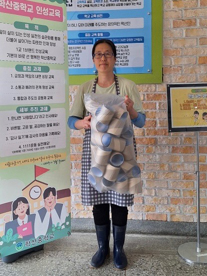 휴지심 나눔을 실천하고 있는 환경미화원 박현수 씨가 근무지 한편에서 나눔을 위해 모은 휴지심을 들고 환하게 웃고 있다. <박현수씨 제공>