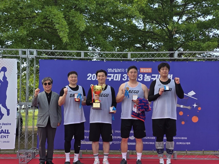 박진관(왼쪽) 영남일보 중부본부장과 대학·일반부 우승팀 '농구숙려캠프'<박용기 기자>
