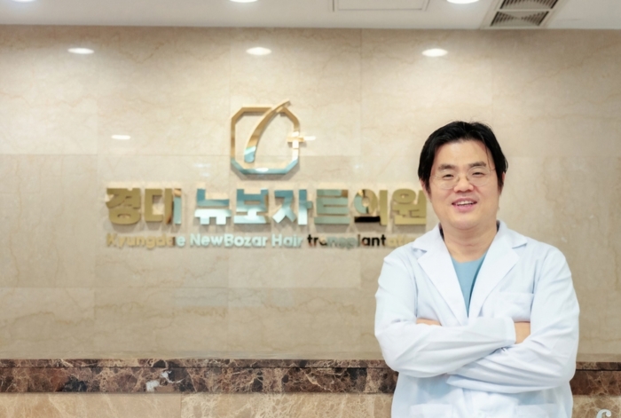 권태정 경대 뉴보자르의원 원장이 진료실 앞에서 환한 미소를 짓고 있다.