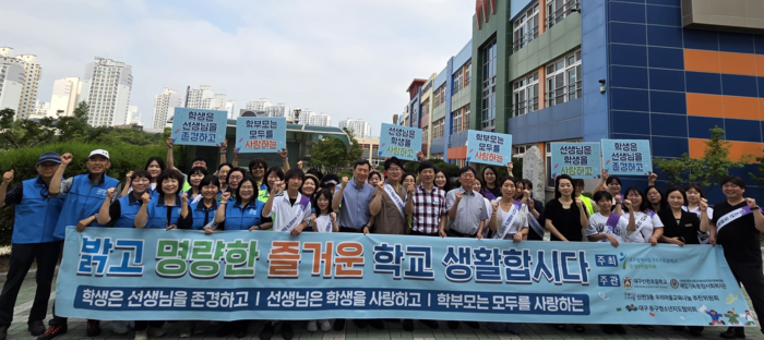 대구동구지구초등학교운영위원협의회가 18일 대구 신천초등학교에서 진행한 '상호존중 연합캠페인' 행사에 참석한 관계자들이 기념촬영을 하고 있다.<제일기독종합사회복지관 제공>