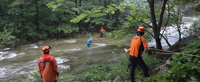 지난 21일 오후 5시 55분쯤 문경시 문경읍 신선암봉에서 하산하던 도중 계곡물 범람으로 고립된 등산객을 소방대원이 구조하고 있다. 경북소방 제공