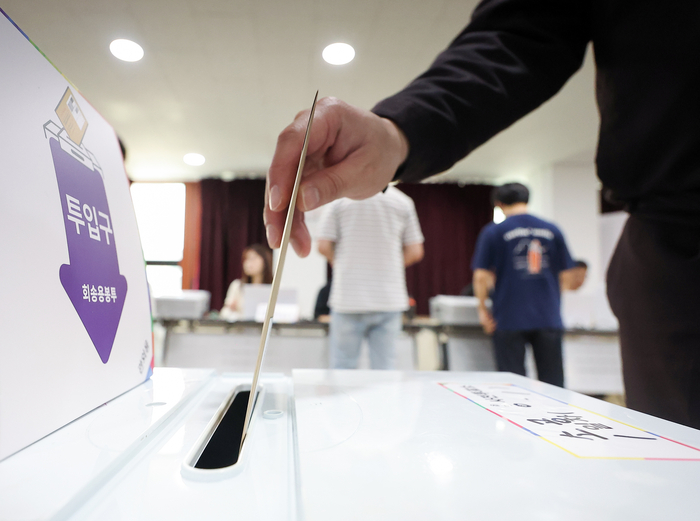 제21대 대통령 선거 사전투표 첫날인 29일 서울 중구 소공동주민센터에 설치된 사전투표소에서 한 유권자가 투표함에 투표용지를 넣고 있다. 연합뉴스