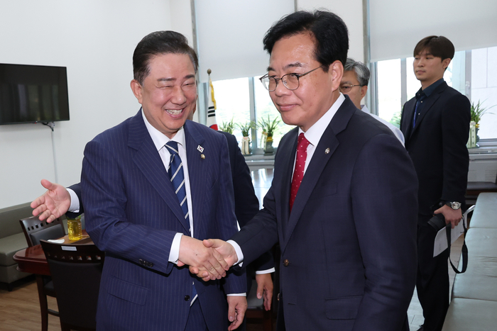 더불어민주당 김병기 당대표 직무대행 겸 원내대표와 국민의힘 송언석 원내대표가 18일 서울 여의도 국회 더불어민주당 원내대표실에서 추경안, 원구성 등 현안을 논의한 뒤 헤어지며 악수하고 있다. 연합뉴스