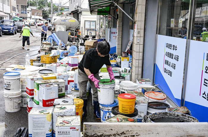 18일 오전 대구 북구 노곡동의 한 페인트 가게 앞에서 주민과 공무원들이 전날 침수된 물품을 정리하고 있다. 노곡동 일대는 전날 집중호우로 주택과 상가 다수가 침수되는 피해를 입었다.
이현덕기자 lhd@yeongnam.com