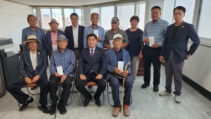 이재출 대한민국상이군경회 경북도지부장(앞줄 오른쪽에서 둘째) 등 지부 관계자들이 산불 피해 상이군경회원들에게 위로금을 전달한 뒤 기념 촬영을 하고 있다.