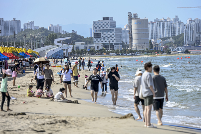 12일 포항 송도해수욕장에서 피서객들이 백사장을 따라 산책하거나 파도에 발을 담그며 한낮 더위를 식히고 있다. 백사장 유실로 폐장됐던 이곳은 수중 방파제 설치와 모래 복원 공사를 거쳐 18년 만에 다시 시민 품으로 돌아왔다.
이현덕기자 lhd@yeongnam.com