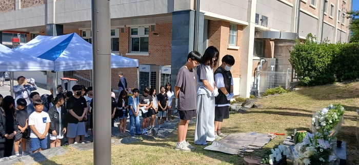 물웅덩이에 빠진 제자를 구하려다 순직한 최명진 선생 추도식에서 학생들이 묵념을 하고 있다. <진량초등 동창회 제공>