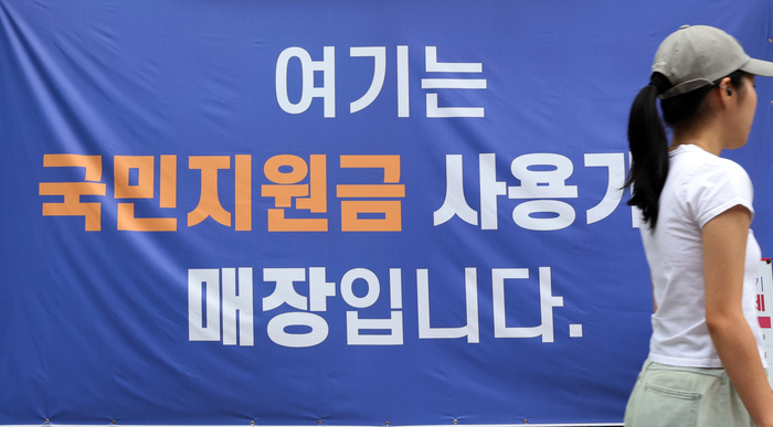 21일 정부의 '민생회복 소비쿠폰' 신청 및 지급이 시작되면서 신용카드사 등 금융권이 '조용한 마케팅'을 펼치고 있다.  사진은 지난 13일 서울 한 상점에 붙은 민생회복 소비쿠폰 사용처 안내문 모습. 연합뉴스