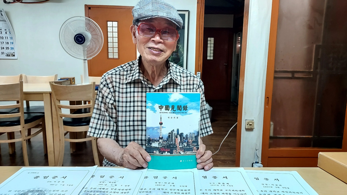 89세의 나이에 학위 5개를 가진 박준희 어르신이 저서인 중국견문록을 소개하고 있다. 책상 위에는 1998년부터 취득한 5개의 학위증서.