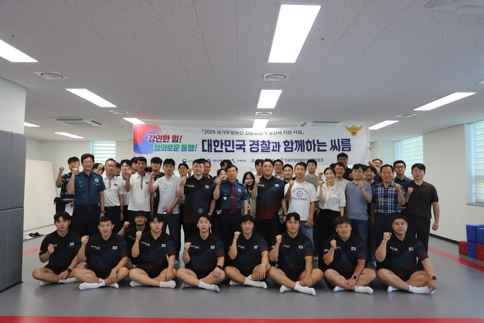 이희석 구미경찰서장과 직원, 이태현 씨름진흥원 이사장, 정창진 구미시청 씨름단 감독 및 선수들이 단체 사진 촬영을 하고 있다. <박용기 기자>
