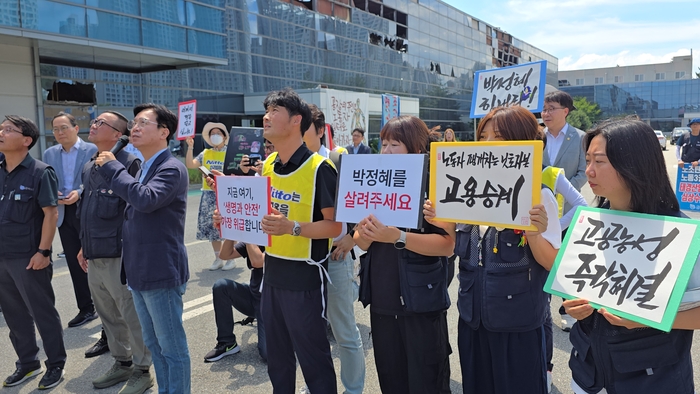 김영훈 고용노동부 장관이 박정혜씨와 마이크로 이야기를 하고 있다. 동료들은 고공농성 해결 및 박씨를 살려달라는 손피켓을 들고 있다. <박용기 기자>