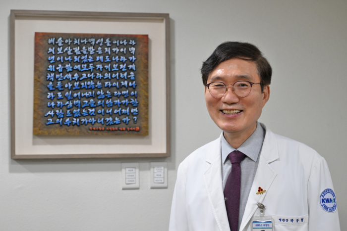 사랑과 봉사를 실천하는 곽동협 곽병원 원장이 병원에 걸린 곽재우 장군의 의병창의 심정을 새긴 액자 앞에서 환하게 웃고 있다. <이지용기자 sajahu@yeongnam.com>