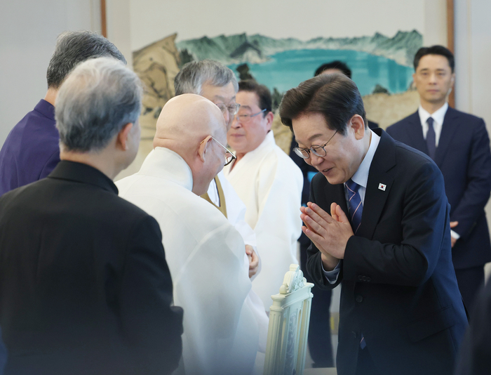 이재명 대통령이 9일 용산 대통령실에서 오찬에 참석한 종교계 지도자들과 인사하며 합장하고 있다. 연합뉴스