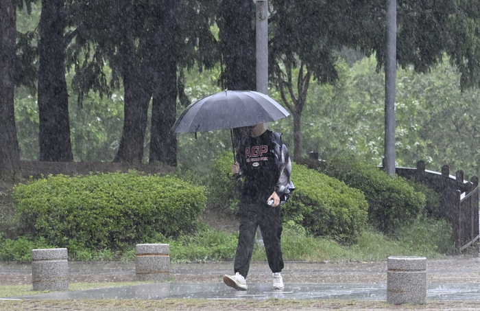 대구지역 호우경보가 발령된 지난달 17일 오후 대구 동구 율하체육공원을 찾은 시민이 우산을 쓰고 이동하고 있다. 
이윤호기자 yoonhohi@yeongnam.com