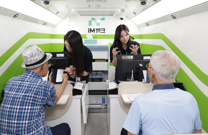 iM뱅크의 이동점포에서 은행원들이 어르신을 대상으로 디지털 금융 교육을 하고 있다. <iM뱅크 제공>